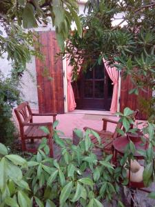 a patio with two chairs and a door with a window at Carlo's Country House in Castellina Marittima