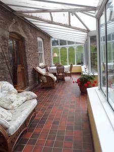 a conservatory with a glass roof and a patio at The Draen Bed and Breakfast in Brecon