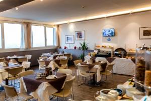 restauracja ze stołami i krzesłami w pokoju w obiekcie Hotel Donatello Imola w mieście Imola
