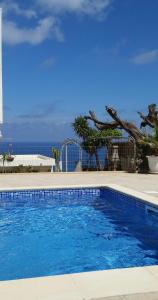 a blue swimming pool with the ocean in the background at Golden View Studios in Líndos