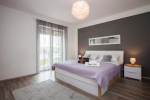 a bedroom with a large bed and a large window at Royal View Apartment in Zadar