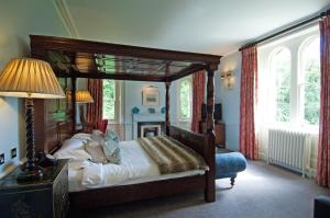 1 dormitorio con cama con dosel y chimenea en Beechfield House, en Beanacre