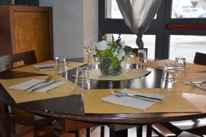 a wooden table with a vase of flowers on it at Piccolo Hotel in Rosignano Solvay