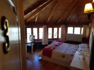 Hotel Vataksi في شكودر: غرفة نوم بسرير ومكتب ونوافذ