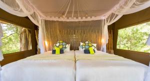 a bedroom with two white beds and a window at Leopard Plains in Motopi