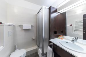 ein Bad mit einem Waschbecken, einem WC und einer Dusche in der Unterkunft Hotel Donatello Imola in Imola