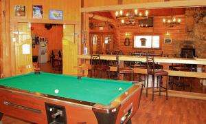 uma mesa de bilhar num quarto com um bar em Cariboo Lodge em Clinton