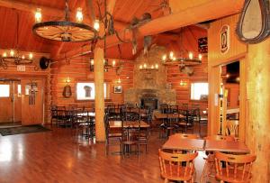 a restaurant with tables and chairs and a fireplace at Cariboo Lodge in Clinton