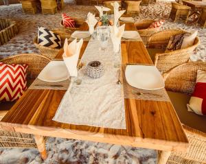 a long wooden table with chairs and glasses on it at Leopard Plains in Motopi