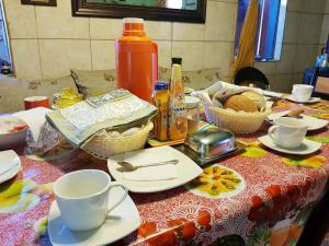 une table avec des tasses, des soucoupes et des plats dessus dans l'établissement Hospedaje María Elena, à Coyhaique 8 autres photos