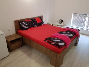a bedroom with a large wooden bed with red sheets at Apartments Alexandra in Opanets