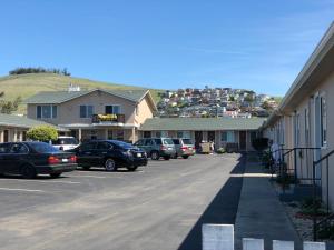 a parking lot with cars parked in front of houses at Holland Inn & Suites in Morro Bay