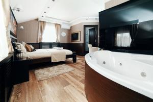 ein großes Bad mit einer Badewanne und einem Bett in der Unterkunft Lux apartmani Beograd in Belgrad