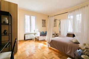 1 dormitorio con 1 cama con cortinas y suelo de madera en HomeHouse Giulio Cesare-San Pietro, en Roma