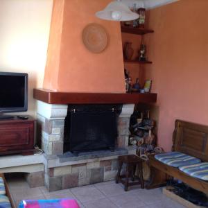 a living room with a fireplace and a tv at Apartamento Rural situado en tercera planta sin ascensor in Navás