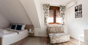 - une chambre avec un lit, une chaise et une fenêtre dans l'établissement Minela Studios, à Mostar