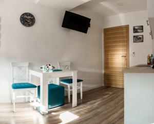 Il comprend une cuisine avec une table et deux chaises ainsi qu'une télévision murale. dans l'établissement Minela Studios, à Mostar