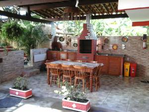 an outdoor kitchen with a table and a stove at Swiss Flats in Porto De Galinhas