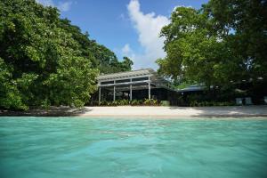 a building on a beach with the water in front at Barrier Beach Resort in Luganville