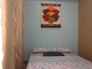 - un lit dans une chambre avec une photo sur le mur dans l'établissement Staycation at Grace Condo Near BGC, à Manille