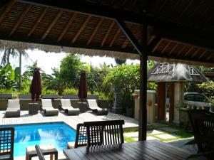 un patio con sillas y una piscina con mesa. en Le Jardin, en Amed