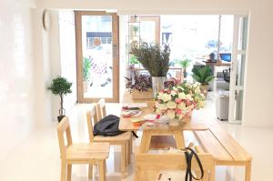 a dining room with a wooden table with flowers on it at About A Bed Hostel Chiangmai in Chiang Mai