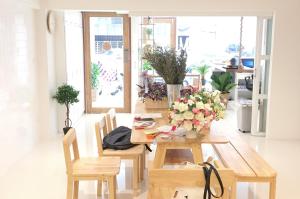 チェンマイにあるAbout A Bed Hostel Chiangmaiのダイニングルーム(花のテーブル付)