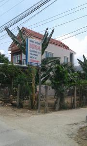 a sign in front of a house with a building at Misa Guesthouse in Dien Khanh