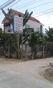 a sign in front of a house with a building at Misa Guesthouse in Dien Khanh