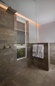 a bathroom with a glass shower with towels at The Tamarind Resort - Nusa Lembongan in Nusa Lembongan