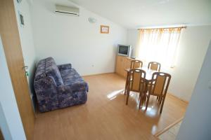 - un salon avec un canapé, une table et des chaises dans l'établissement Apartments Maric with parking, à Umag