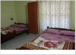 a bedroom with two beds and a window at Lahari Welcomes You in Madikeri