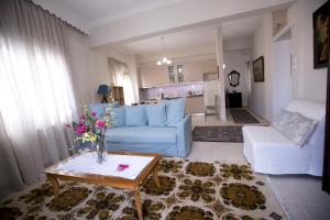 een woonkamer met een blauwe bank en een tafel bij Nick n Sophie's in Kavala
