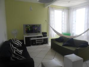 a living room with a couch and a hammock at Mar da Babilônia Hostel in Rio de Janeiro