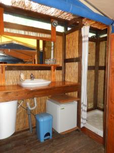 Un baño en una cabaña con lavabo y encimera. en Amfibietreks, en Siniscola