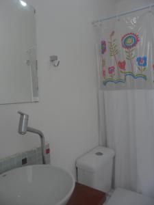 a bathroom with a white toilet and a sink at Mar da Babilônia Hostel in Rio de Janeiro