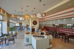 a restaurant with tables and chairs and a bar at Safir Fintas Hotel Kuwait in Kuwait