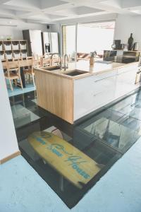 a kitchen with a surfboard on a glass floor at BodyGo Surfhouse in Capbreton