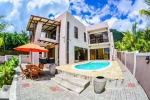 - une vue sur l'extérieur d'une maison avec une piscine dans l'établissement Villa Chan, à Tamarin