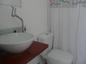 a bathroom with a white sink and a toilet at Mar da Babilônia Hostel in Rio de Janeiro +21 photos