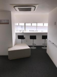 a room with three chairs and a bed in it at Santiago Guesthouse Kyoto in Kyoto