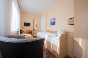 ein Hotelzimmer mit einem Bett und einem Stuhl in der Unterkunft Hotel Joh in Bad Salzuflen