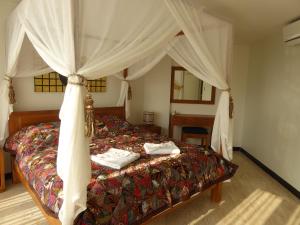班菲的住宿－The Orchid Beach Resort @ VIP Chain Resort，一间卧室配有一张带天蓬的床