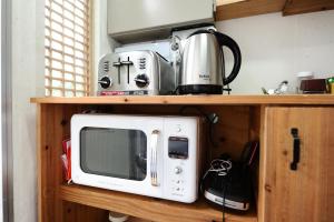 a microwave sitting on top of a wooden shelf at Starlight Rest Area in Jeonju