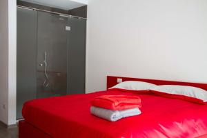 a red bed with red sheets and towels on it at Ingrappa Sporthouse in Borso del Grappa