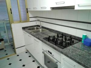 a kitchen with a stove and a sink at Rodafam in Playa de Miramar