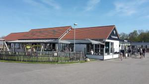 a building with a restaurant with people standing outside at Strandcamping Valkenisse in Biggekerke