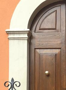 a wooden door with an arch above it on a building at Lo Sghimbescio in Marradi