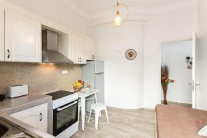 a kitchen with white cabinets and a small white table at Relax Studios in Naxos Chora