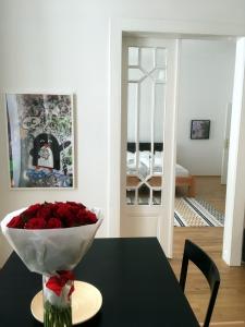 una mesa con un jarrón de rosas encima en Apartments near Rathaus, en Viena